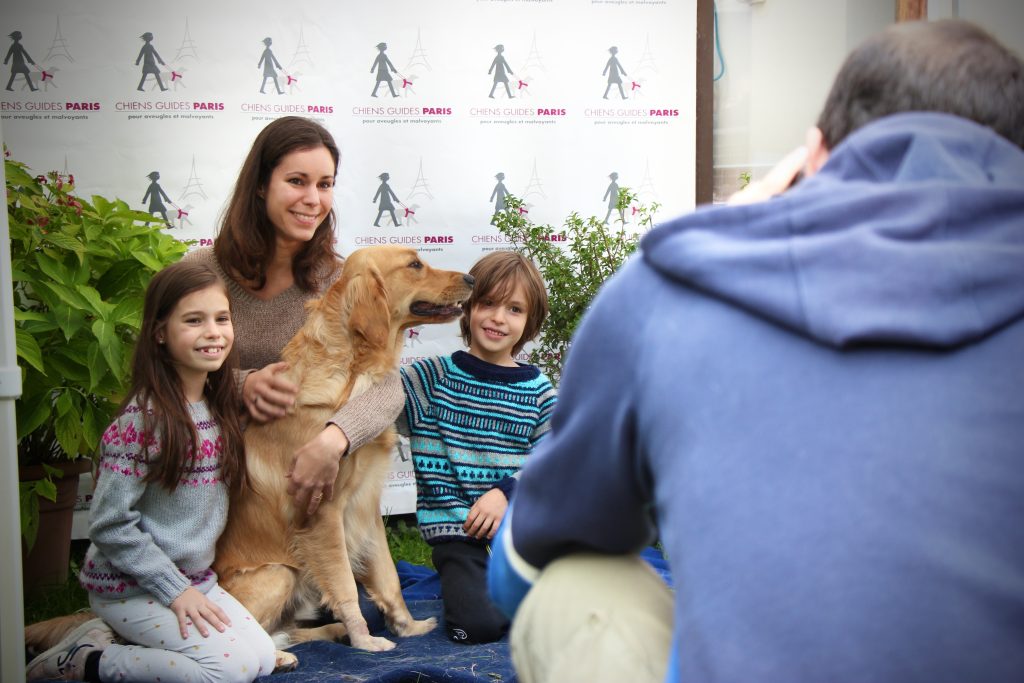 Une famille prend une photo avec un chien sur le stand photo de la JPO 