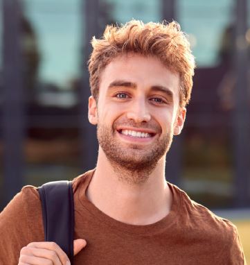 Pierre, jeune homme d'une trentaine d'année est debout et souriant.