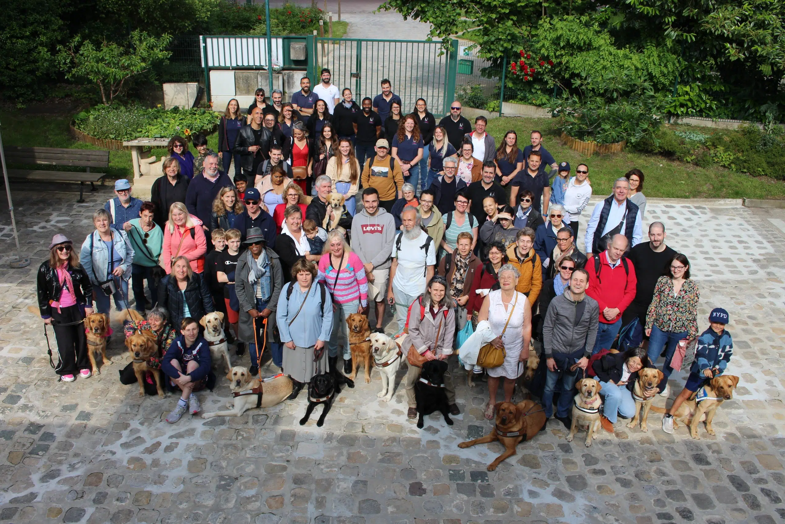 Photo regroupant éducateurs, moniteurs, familles d'accueil, maîtres de chiens guides et les chiens guides 