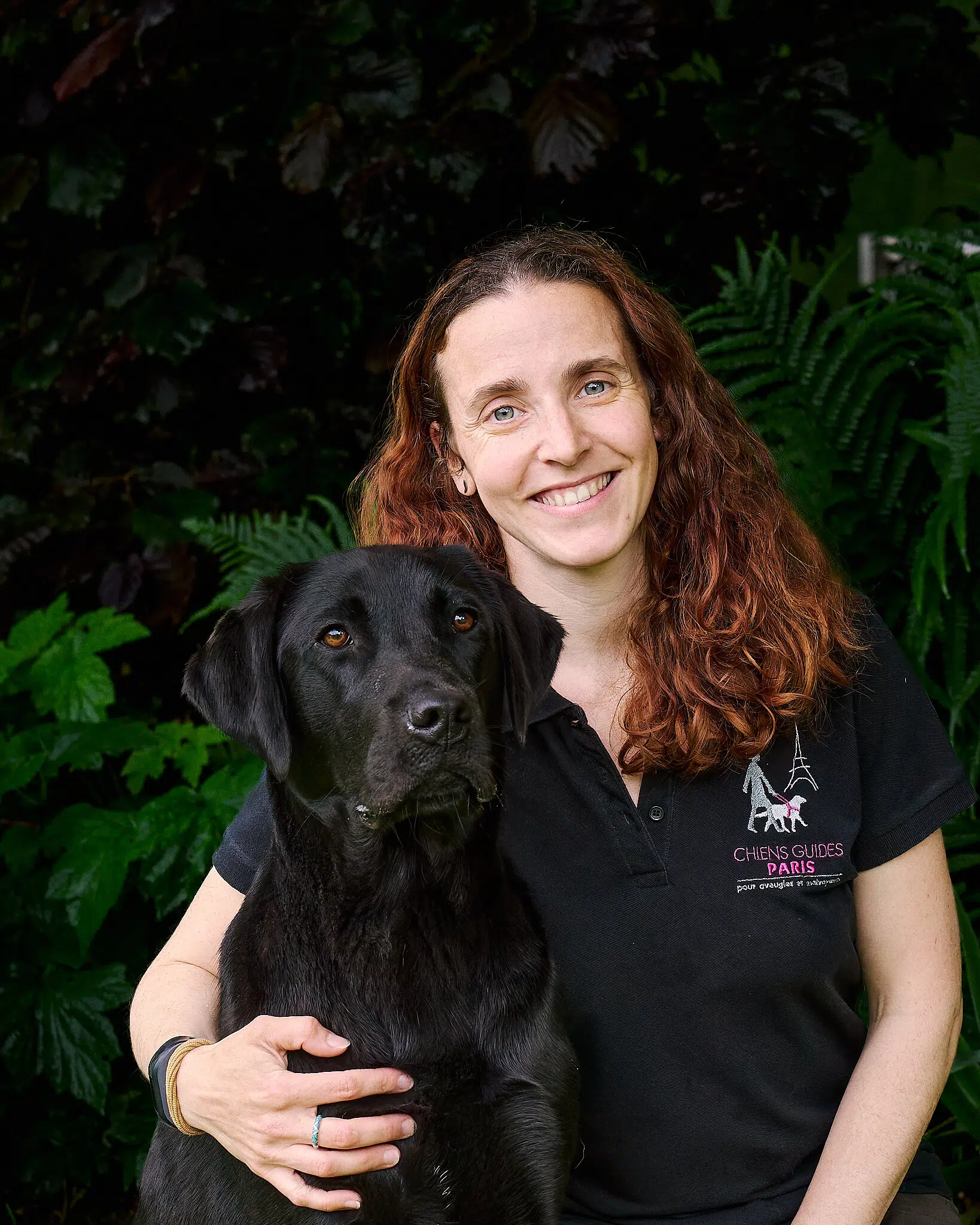 Amanda posant avec Ucar, labrador noir