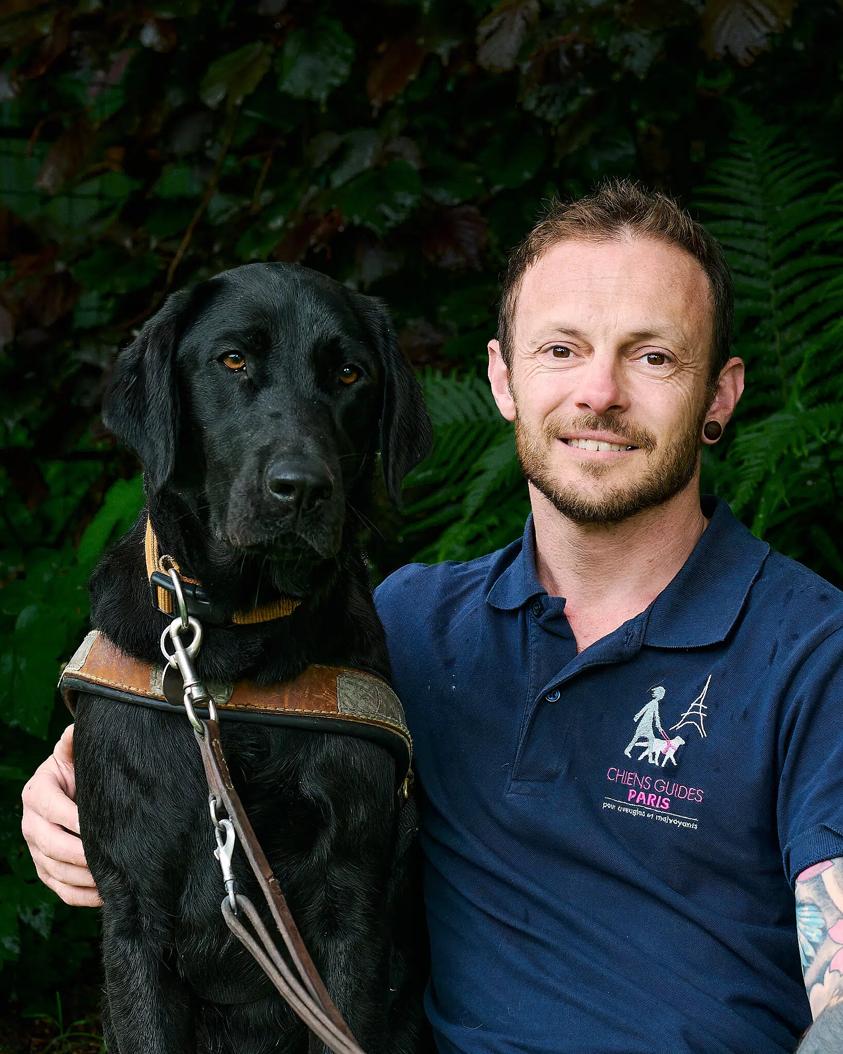 Mathieu posant avec Toulouse, labrador noir