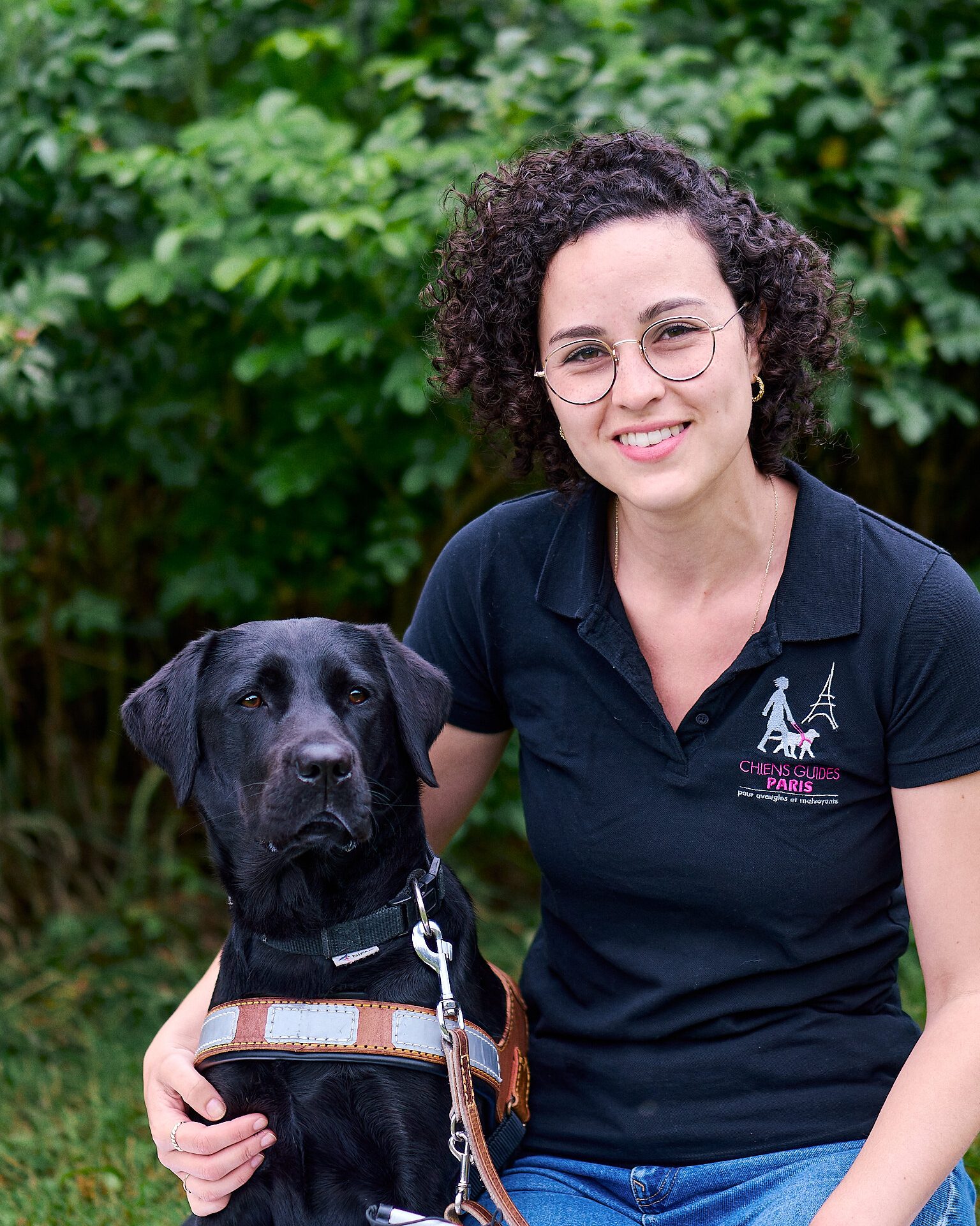 Noémie posant avec Taïni, labrador noire