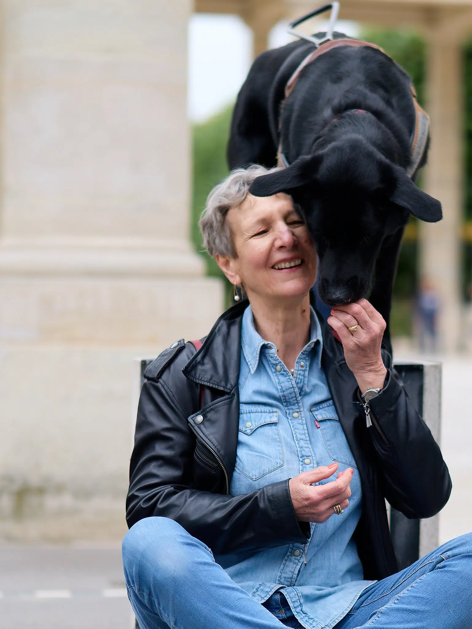 Martine assise et qui donne une croquette a Rusty