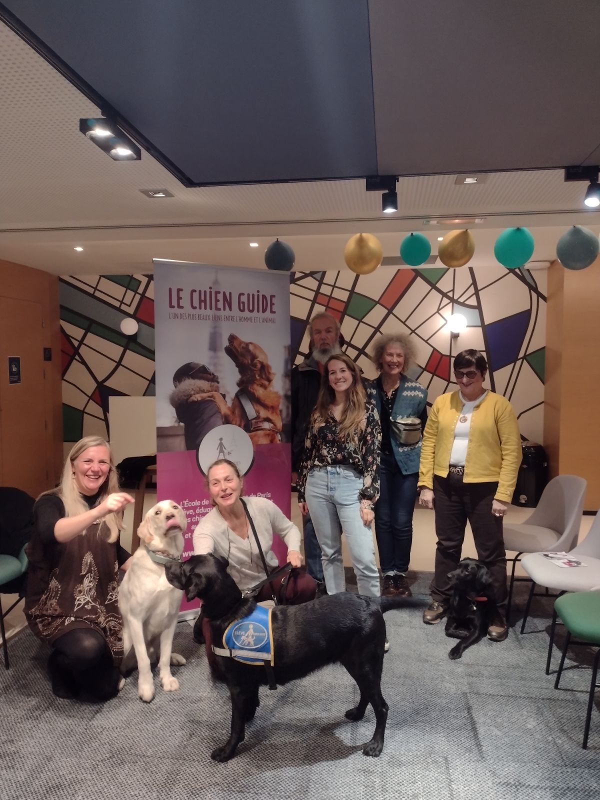 Photo des administrateurs de l'École de Chiens Guides de Paris, prise devant le kakemono de l'école.